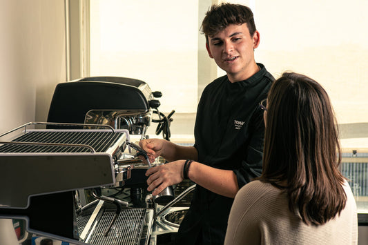 Chicchi di caffè tostati in mano, torrefazione Tomassi Coffee ad Aprilia