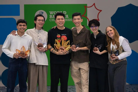 I sei finalisti del World Barista Championship 2026 sul palco di Panama con i trofei, al centro il campione Pan Wei (foto World Coffee Championships)